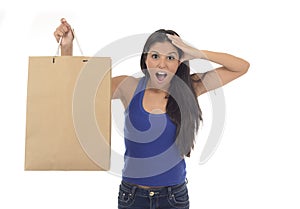 Young happy and beautiful hispanic woman holding brown shopping