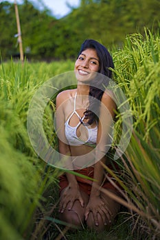 Young happy and beautiful latin woman smiling playful having fun posing sexy isolated on green rice field in Asia tourist trip and