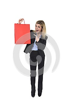 Young happy beautiful woman in business suit in excited face expression holding red shopping bag