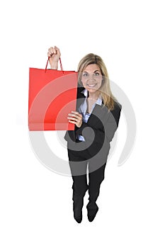 Young happy beautiful woman in business suit in excited face expression holding red shopping bag