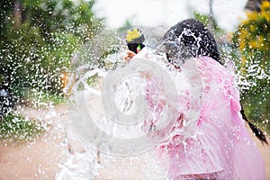 Young happy beauty Asian girl with water gun wearing summer shirt in Songkran festival - water festival in Thailand