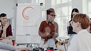 Young happy black woman boss leading team discussion meeting at modern multiethnic healthy office slow motion RED EPIC.