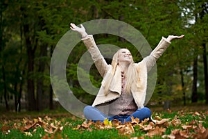 Young happy blonde woman walking in autumn park