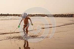 Young happy boy jumping into the air on beach