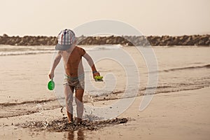 Young happy boy jumping into the air on tropical beach