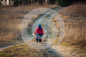 Young happy boy playing outdoor on country road