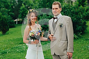 Young happy bride and groom on the background of greenery