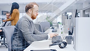 Young Happy Business Salesman Specialist Works with His Desktop Computer in Bright Modern Office.