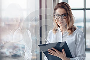 Young happy business woman holding a folder of documents