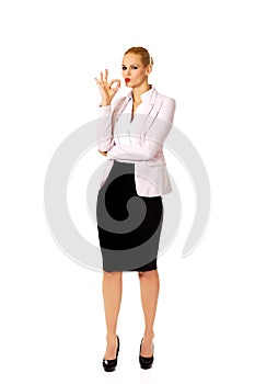 Young happy business woman shows OK sign