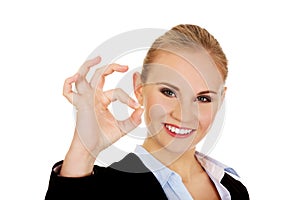 Young happy business woman shows OK sign