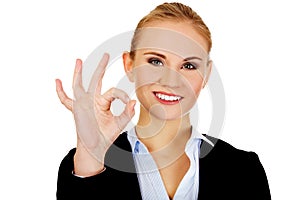 Young happy business woman shows OK sign