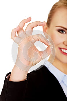 Young happy business woman shows OK sign