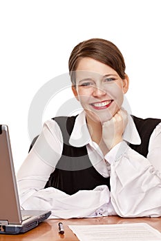 Young happy business woman sits on desk in office
