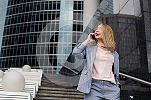 Business woman talking on the phone in the background of an office building