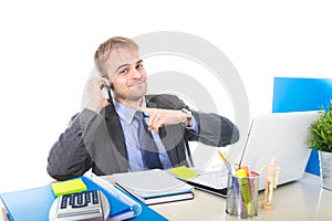Young happy businessman smiling confident talking on mobile phone at office computer desk
