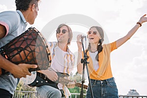 Young happy buskers having fun playing music and singing