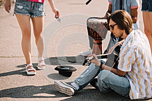 Young happy buskers playing an improvised concert at city street and receiving photo