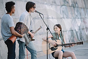 Young happy buskers playing music and singing photo
