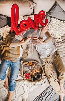 Young happy caucasian couple having breakfast in bed