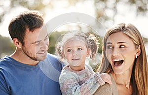 Young happy caucasian family having fun and relaxing in nature. Loving parents spending time with their little daughter