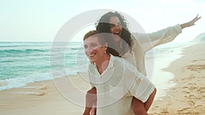 Young happy Caucasian man and Indian woman have good time at seaside resort