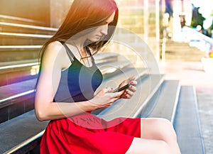 Young happy caucasian woman texting sms in city outdoor. Relax lifestyle summer concept