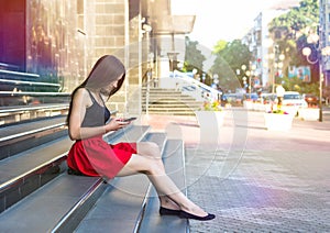 Young happy caucasian woman texting sms in city outdoor. Relax lifestyle summer concept