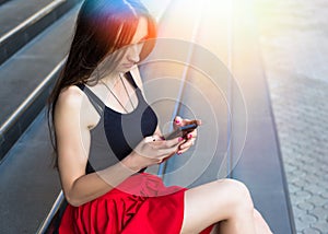 Young happy caucasian woman texting sms in city outdoor. Relax lifestyle summer concept