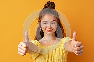 Young happy cheerful woman showing thumb up .in studio