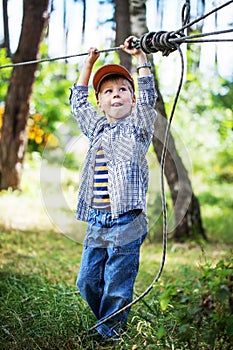 Young happy child boy in adventure park.