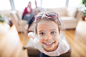 Young happy child with parents in the background packing for holidays.