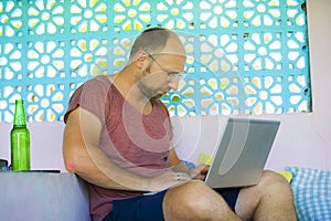 Young happy and confident backpacker man working with laptop computer outdoors relaxed as freelance entrepreneur and digital nomad