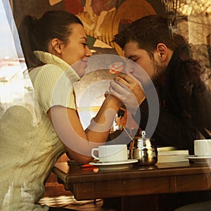 Young happy couple in cafe, view through a window