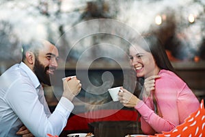 Young happy couple in cafe, view through a window