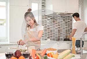 young happy couple cooking together in the kitchen at home