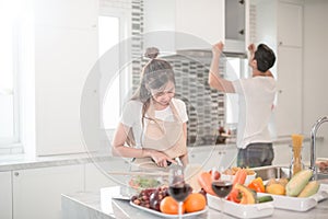 Young happy couple cooking together in the kitchen at home