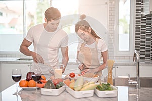 Young happy couple cooking together in the kitchen at home