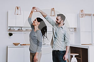 Young Happy Couple Dancing in Modern Kitchen.