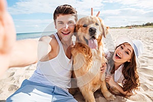 Young happy couple with dog taking a selfie