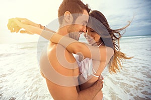 Young happy couple with draw heart on tropical beach