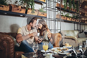 Young happy couple eating pizza in a restaurant