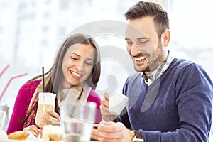 Young happy couple enjoying in coffee shop