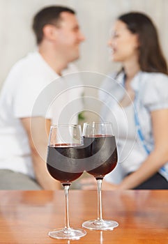 Young happy couple enjoying a glasses of red wine