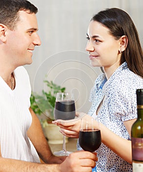 Young happy couple enjoying a glasses of red wine