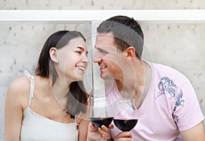 Young happy couple enjoying a glasses of red wine