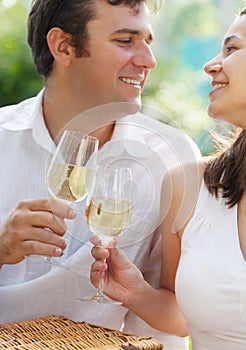 Young happy couple enjoying a glasses of white wine