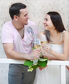 Young happy couple enjoying a glasses of white wine