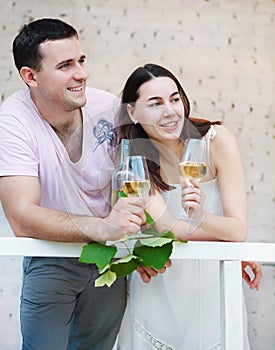 Young happy couple enjoying a glasses of white wine