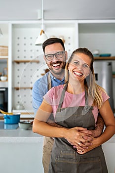 Young happy couple is enjoying and preparing healthy meal in their kitchen together